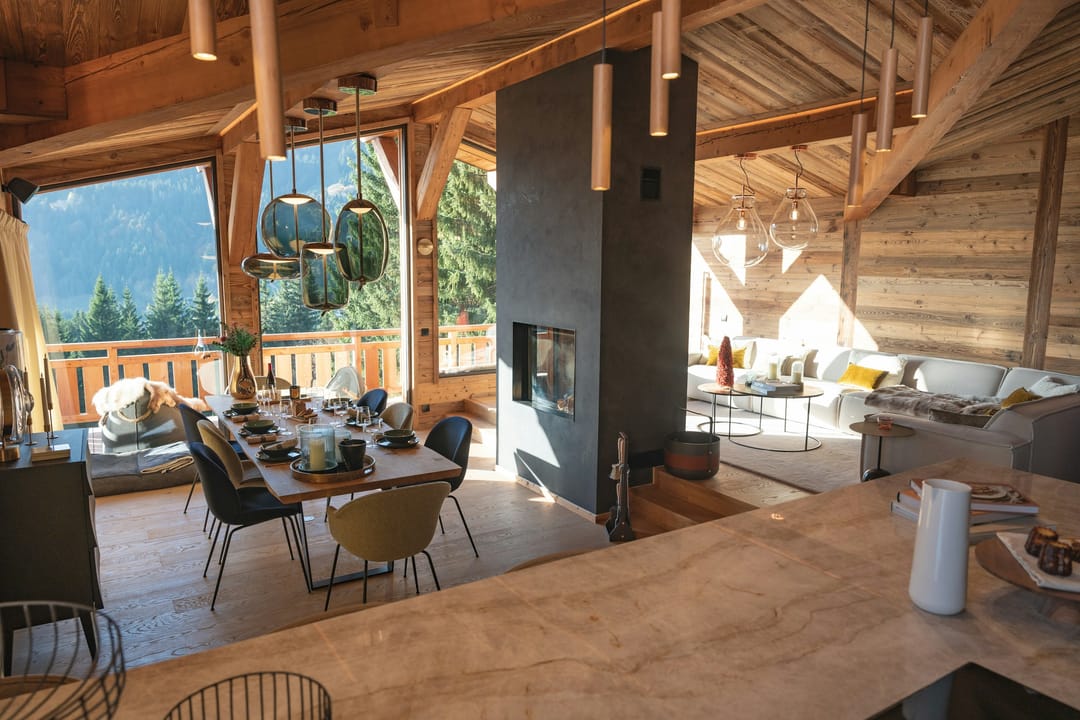 Offener Wohn- und Essbereich eines Chalets mit Blick in die Berge