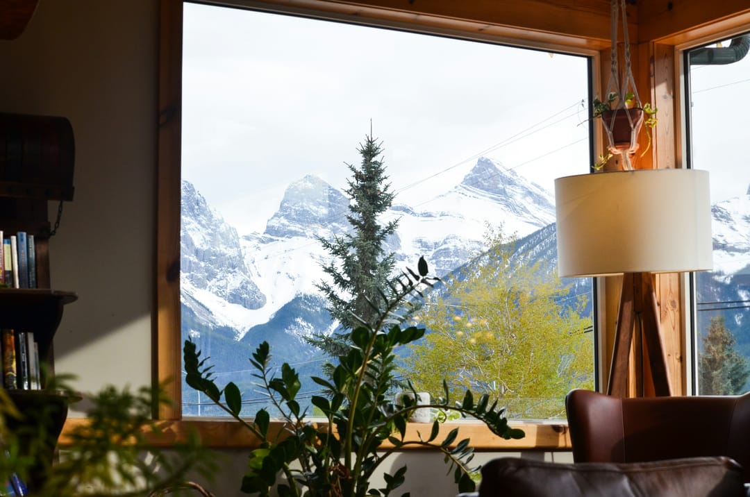 Wohnraum mit grossem Fenster und Blick auf verschneite Berge
